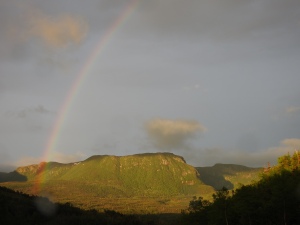 A rainbow stretches across the green hills of Gros Morne.